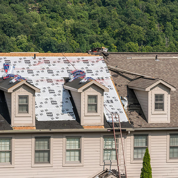 Residential home about to have it's brown shingles replaced with GAF shingles