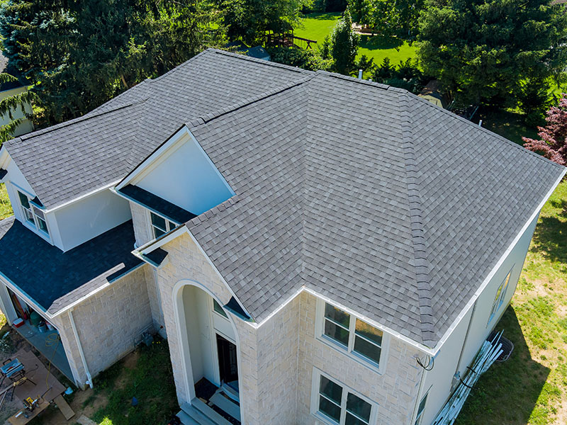 Top and side view of home with brand new gray shingles on it